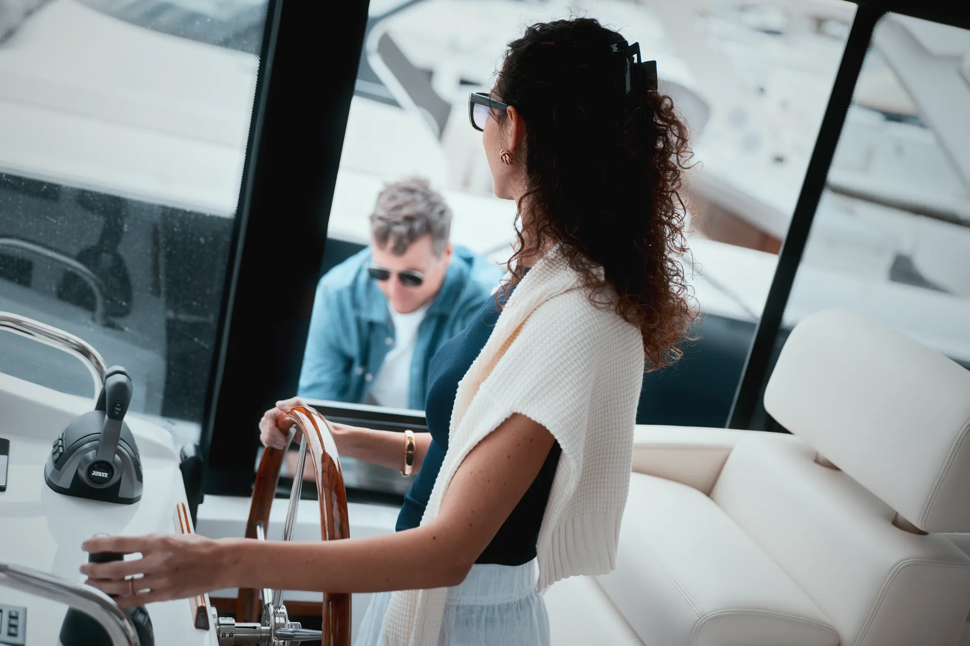 A woman steering an MJM yacht from the helm